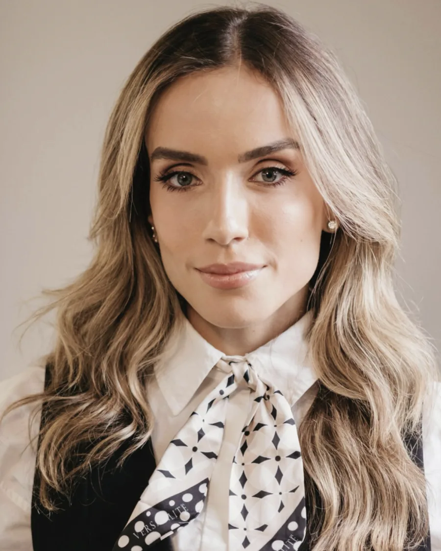 Retrato de Ana Libório, de cabelos longos e ondulados, com lenço estampado em preto e branco sobre a camisa branca.