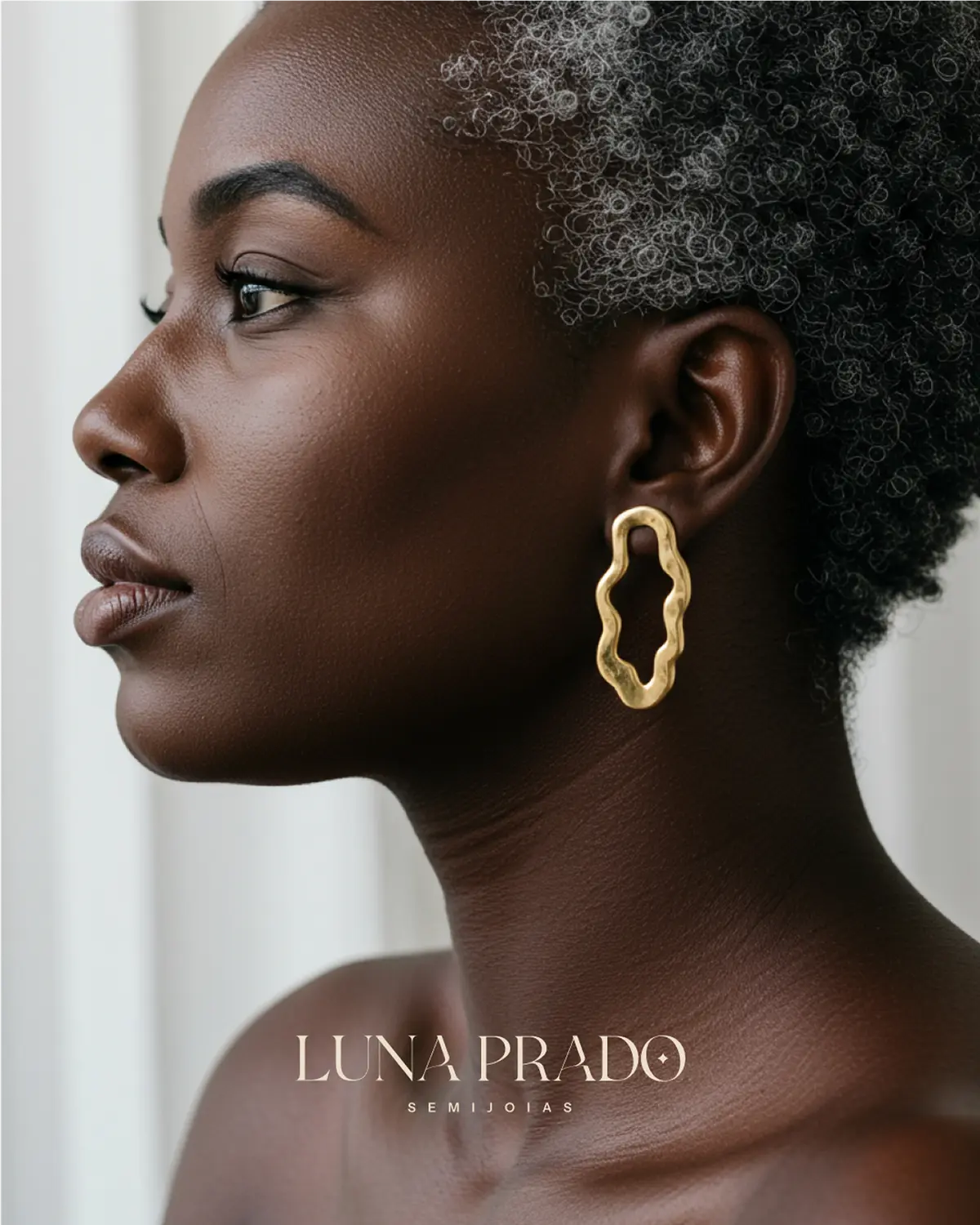 Retrato de perfil de mulher com brinco dourado e o logo de Luna Prado.